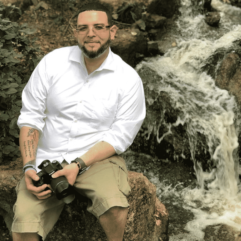 alex rodriguez leaning against waterfall